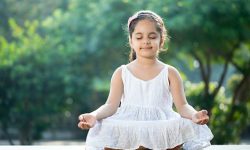 Little girl meditating outdoors at park